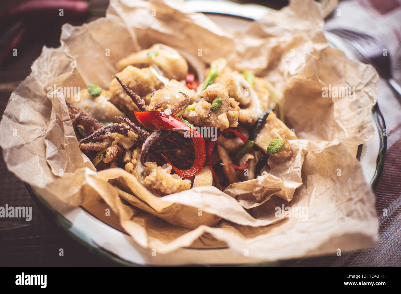 Fresh Calamari Squids with Organic Red Hot Chili Peppers in Rustic Plate Stock Photo