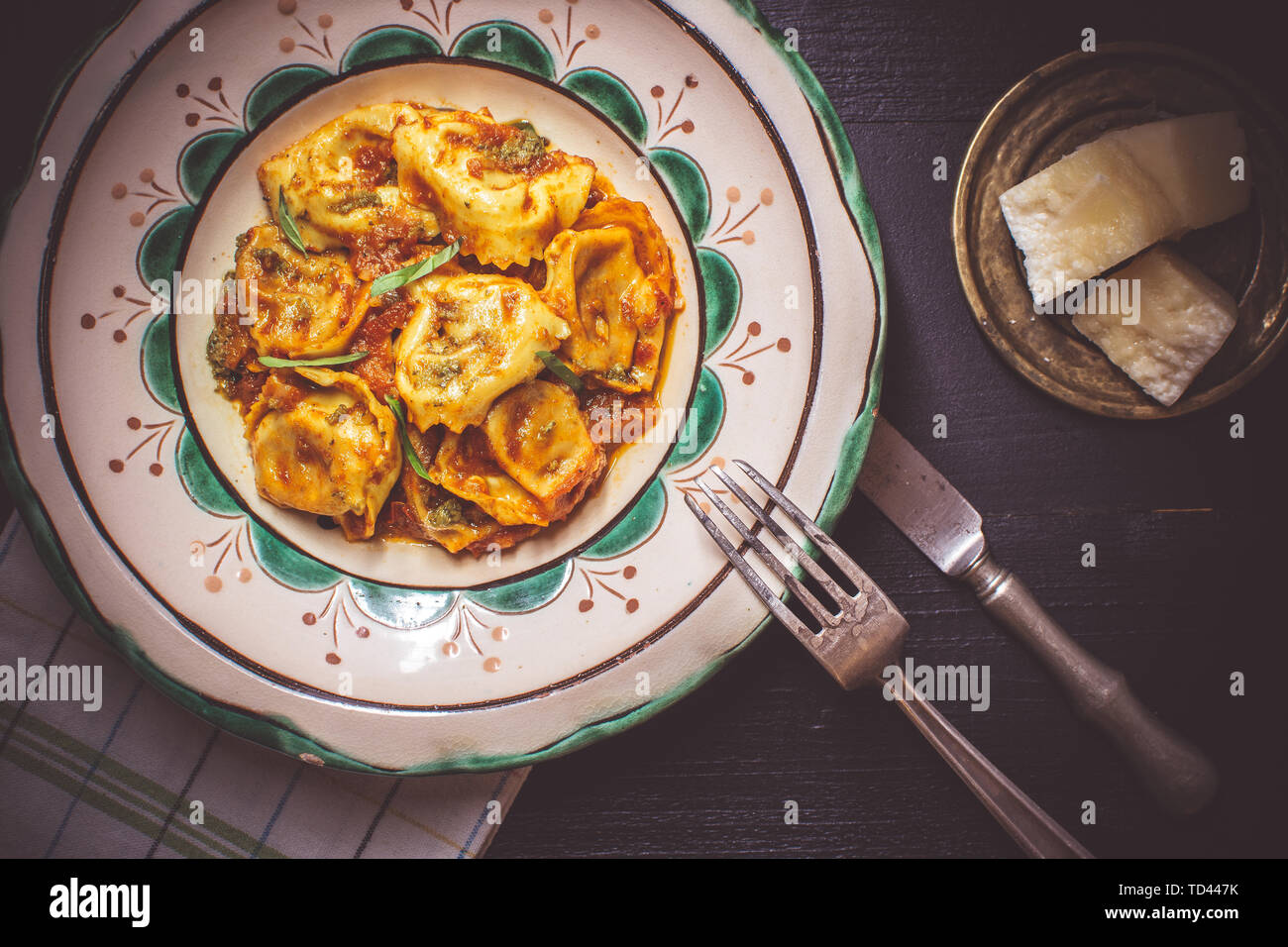 Fresh Tortellini with Tomato Sauce, Organic Mozzarella Cheese and Basil on Rustic Plate Stock Photo