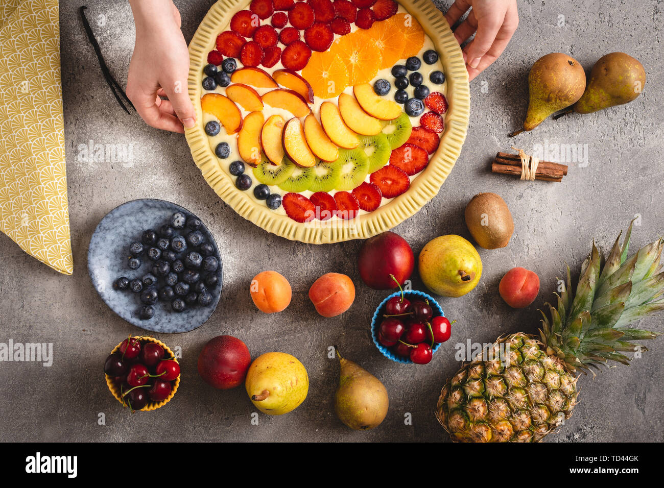 Female Hands Prepare Tart Pie with Fresh Dough and Colorful Organic Fruits Stock Photo