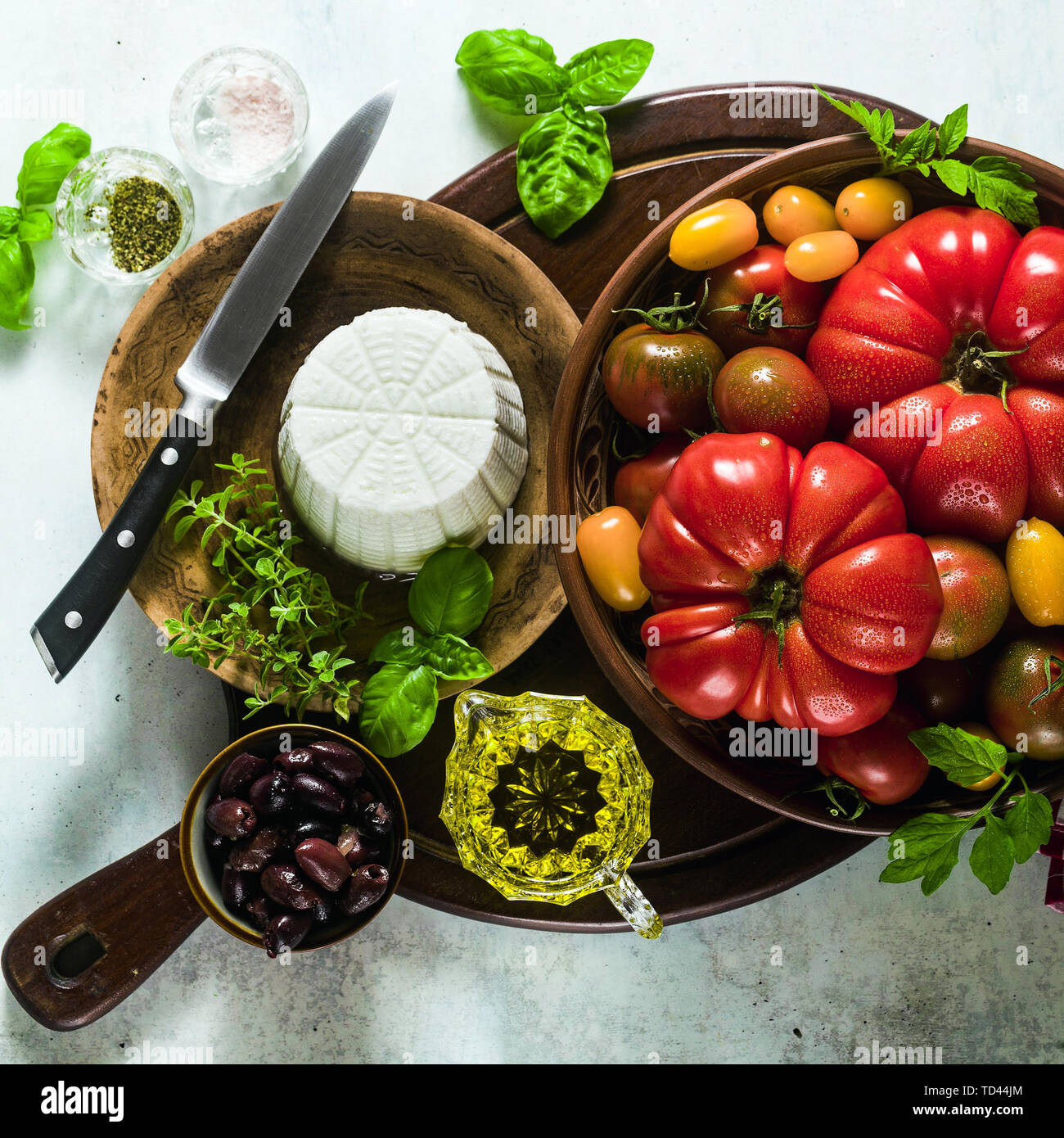 ingredients for the preparation of summer salad of colorful tomatoes, olives and ricotta. Mediterranean recipes Stock Photo