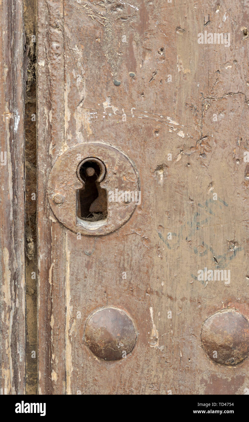 Keyhole in an old paneled wooden door; rusty and weathered Stock Photo