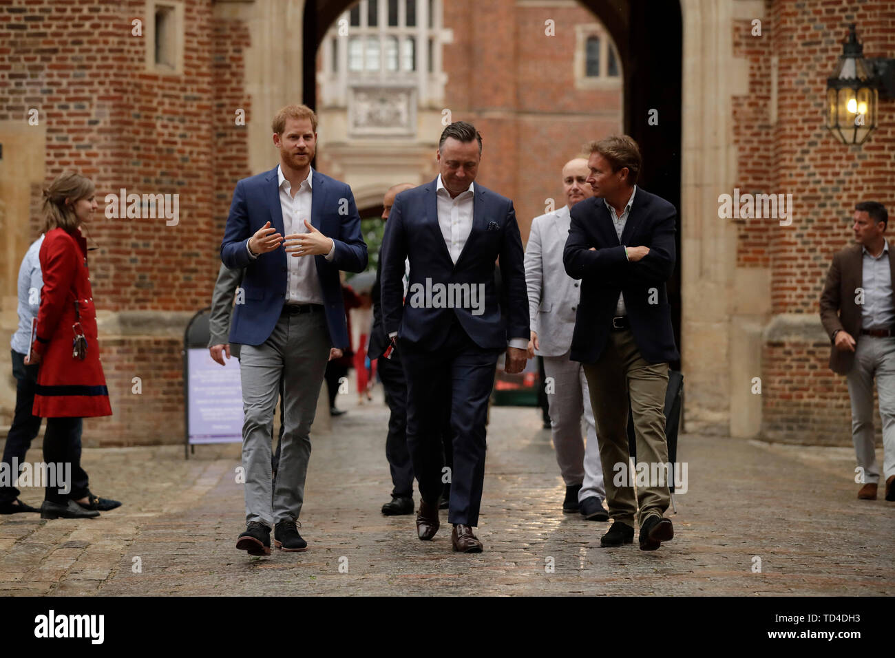 The Duke of Sussex walks with the Managing Director of Audi UK Andrew Doyle (centre) and the Chairman of Sentebale Johnny Hornby before a concert hosted by Sentebale in Hampton Court Palace in East Molesey, to raise awareness and vital funds for the Duke's charity, Sentebale, which helps young people in southern Africa affected by HIV. Stock Photo