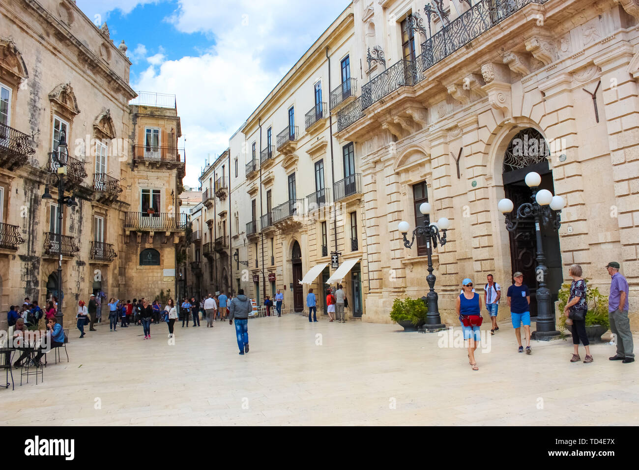 Syracuse, Sicily, Italy - Apr 10th 2019: People walking on the Piazza Duomo Square in the historical center. The center is located on the famous Ortigia Island. Popular tourist attraction. Stock Photo