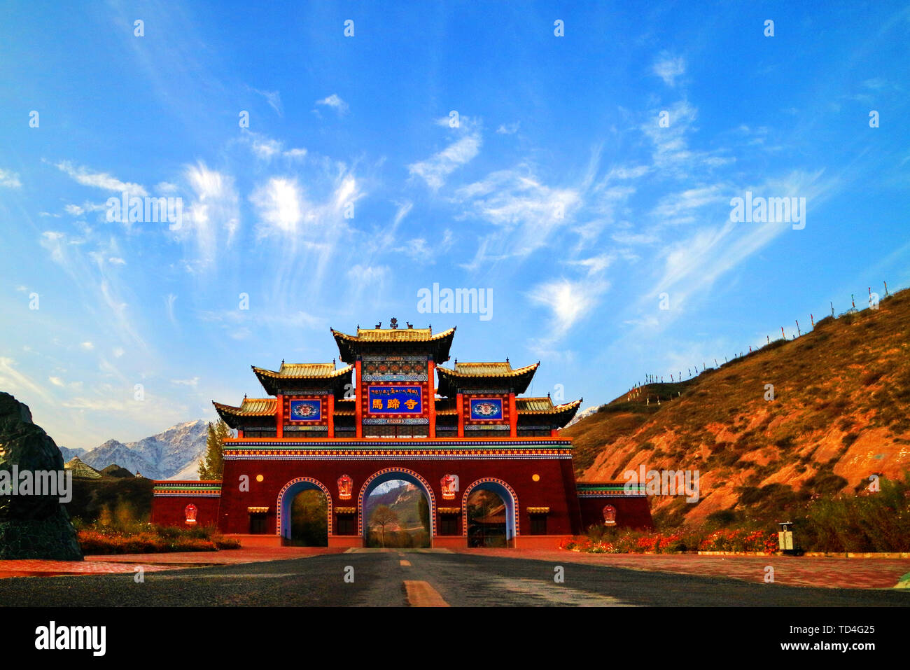 Horseshoe Temple is located in the Yugu Autonomous County of Sunan Province, Gansu Province. It is a tourist area that integrates grotto art, Qilian Mountain scenery and Yugu style. Horseshoe Temple is named for the legendary celestial horse drinking water with horseshoe prints. In the picture, the clouds above the door building of the Horseshoe Temple are just like ten thousand horses Pentium. Stock Photo