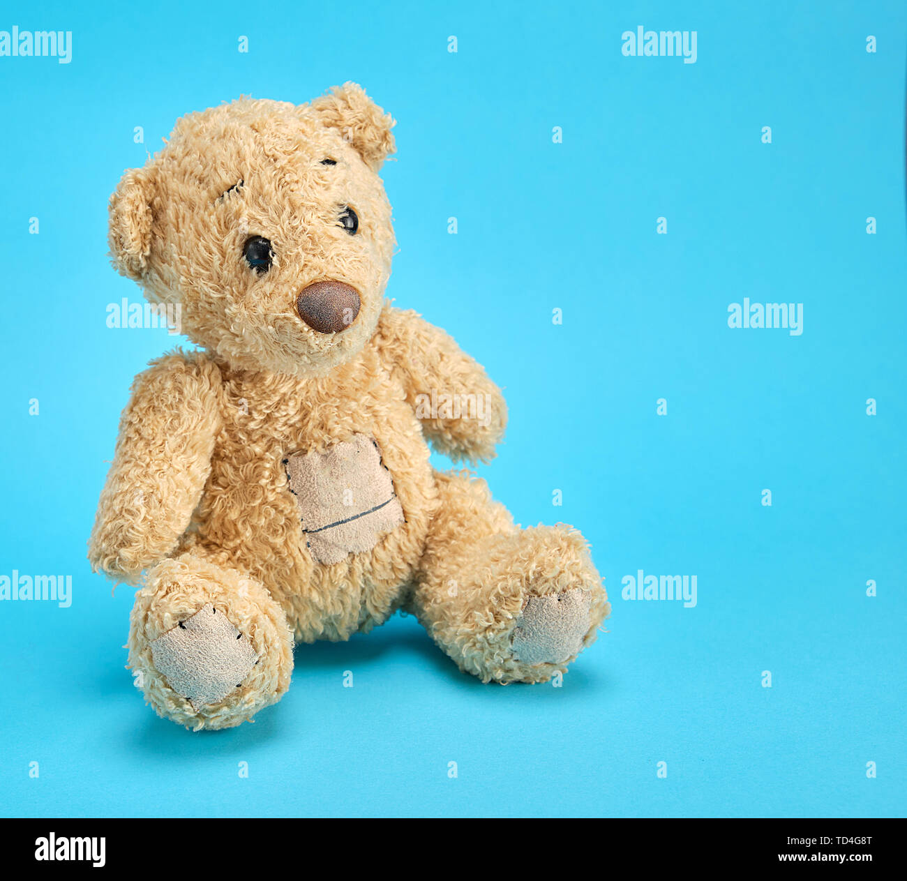 old brown teddy bear on a blue background, copy space Stock Photo - Alamy