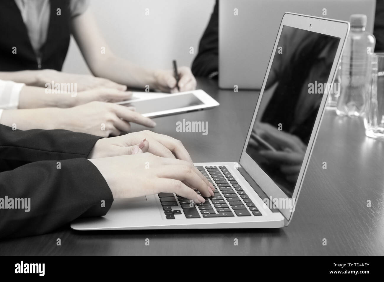 Female hands with digital tablet on office background in shades of grey ...