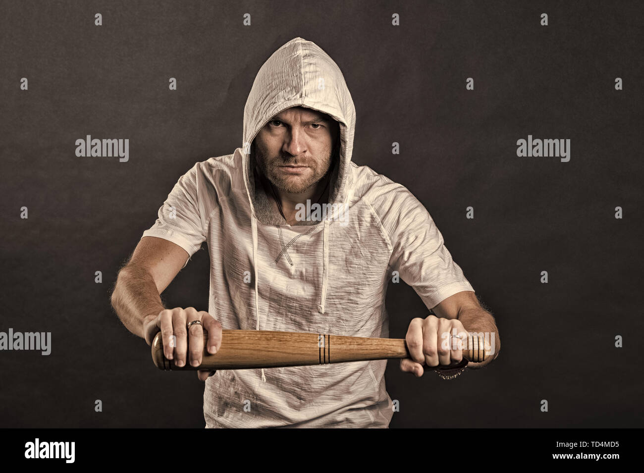 Hooligan hold baseball bat. Bearded man wear hood in hoodie tshirt