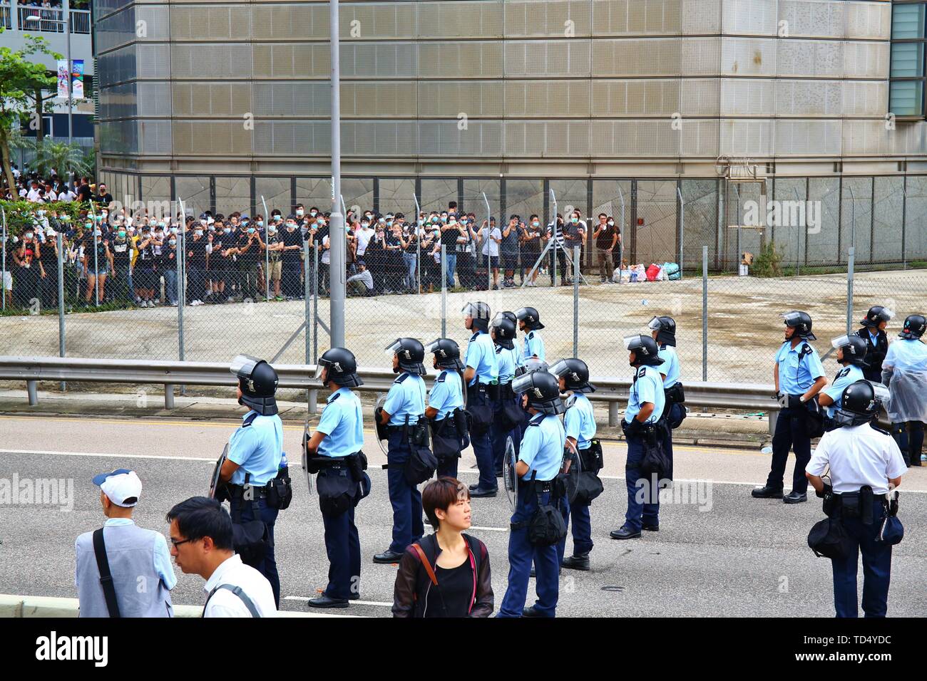 Hong Kong. 12th June, 2019. Hong Kong - June 12, 2019. Thousands of protesters have surrounded government buildings in Hong Kong in protest of a controversial extradition bill. The police is setting up control barriers at Harcourt Road. Credit: Gonzales Photo/Alamy Live News Stock Photo