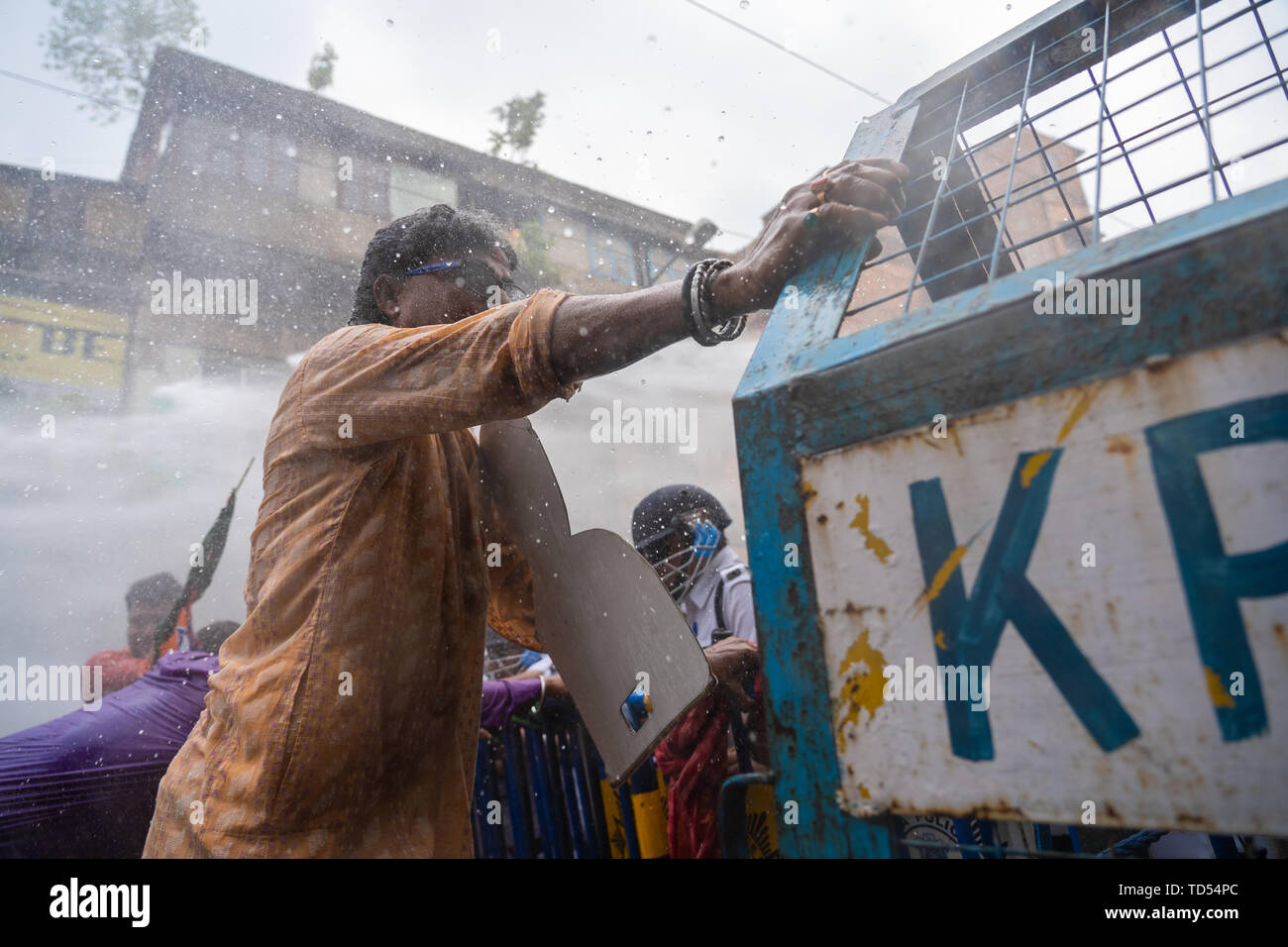 Kolkata, India. 12th June, 2019. Kolkata, India. 12th June, 2019. A Bharatiya Janata Party (BJP) supporter attempts to break through a police barricade amidst water cannons during the protest in Kolkata. Bharatiya Janata Party workers protest against the killings of the BJP workers and also highlighting the alleged deterioration of law and order in the state, the Police used water cannons and tear gas shells towards the protesters who held a rally at Kolkata Police headquarters. Credit: SOPA Images Limited/Alamy Live News Stock Photo