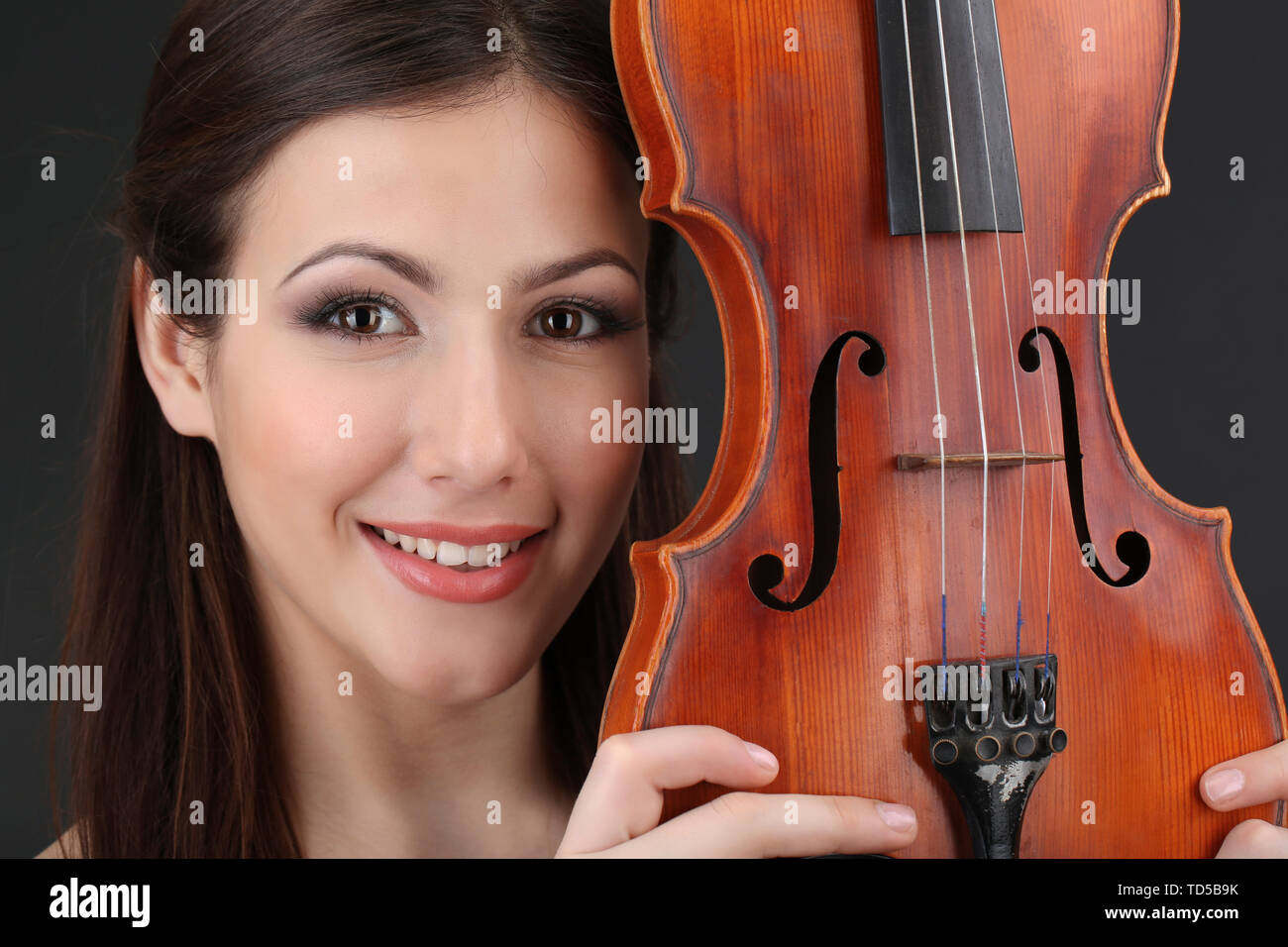 Beautiful young girl with violin on grey background Stock Photo - Alamy