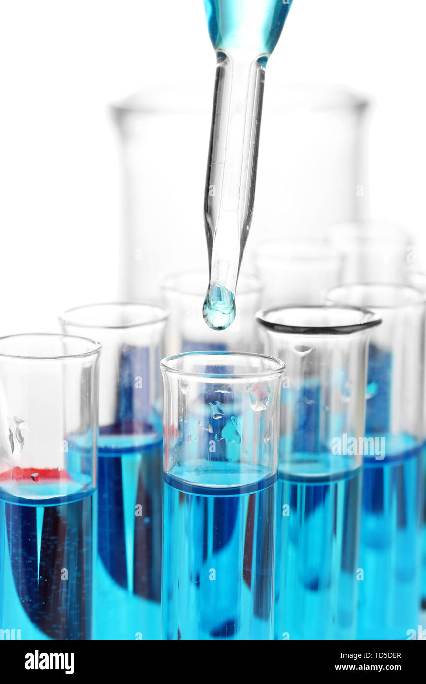 Laboratory pipette with drop of color liquid over glass test tubes ...