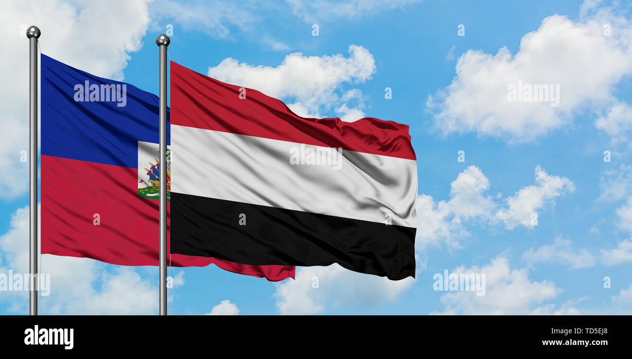 Haiti and Yemen flag waving in the wind against white cloudy blue sky together. Diplomacy concept, international relations. Stock Photo