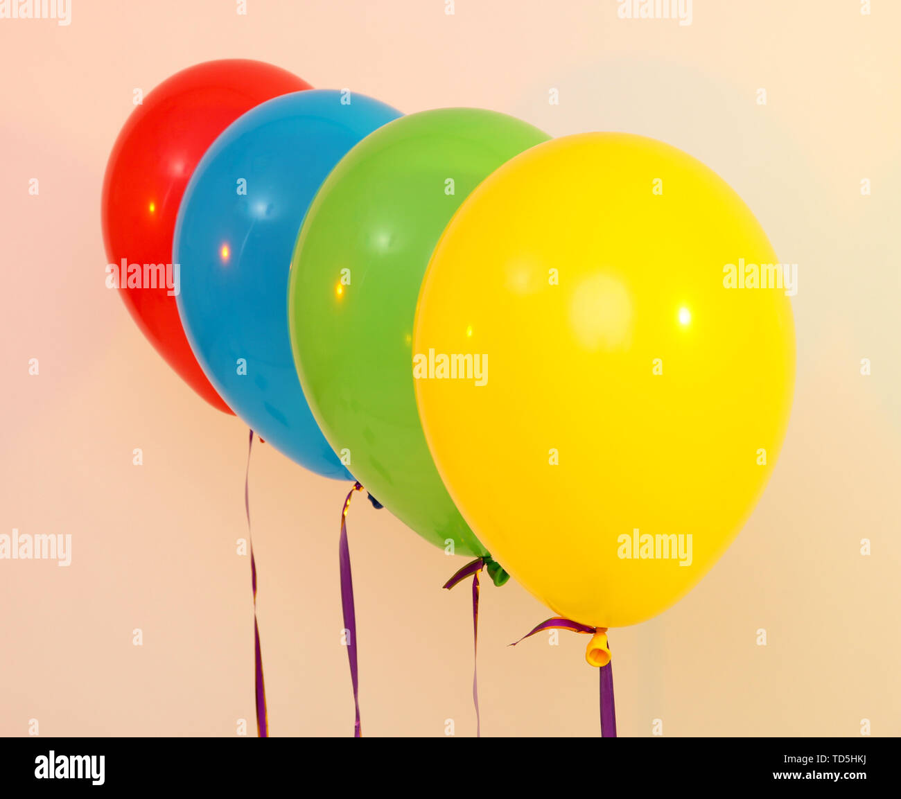 Four bright balloons on light background Stock Photo - Alamy