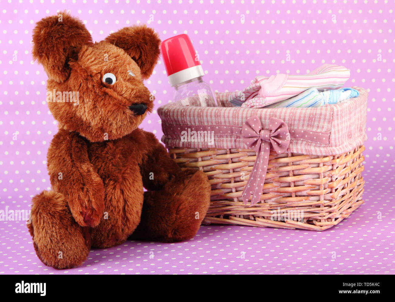 Beautiful basket of baby clothes on a pink background Stock Photo - Alamy