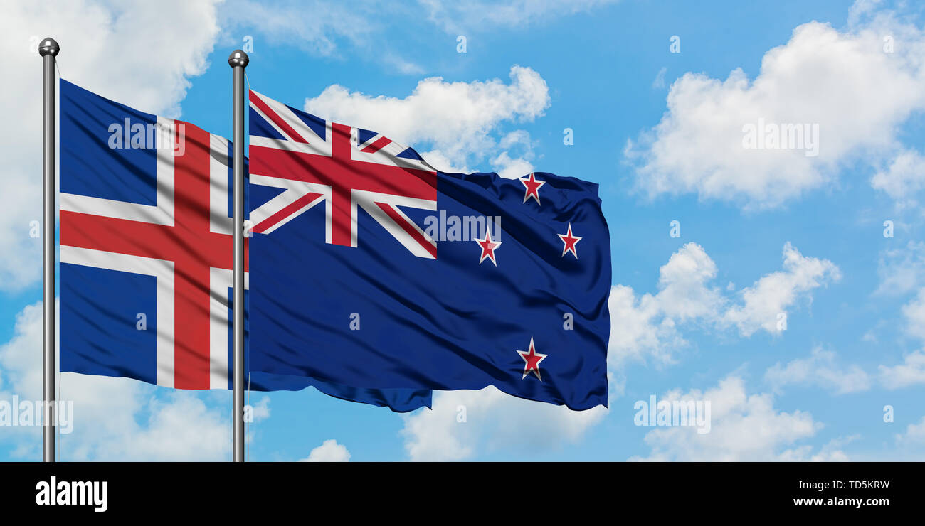 Iceland and New Zealand flag waving in the wind against white cloudy