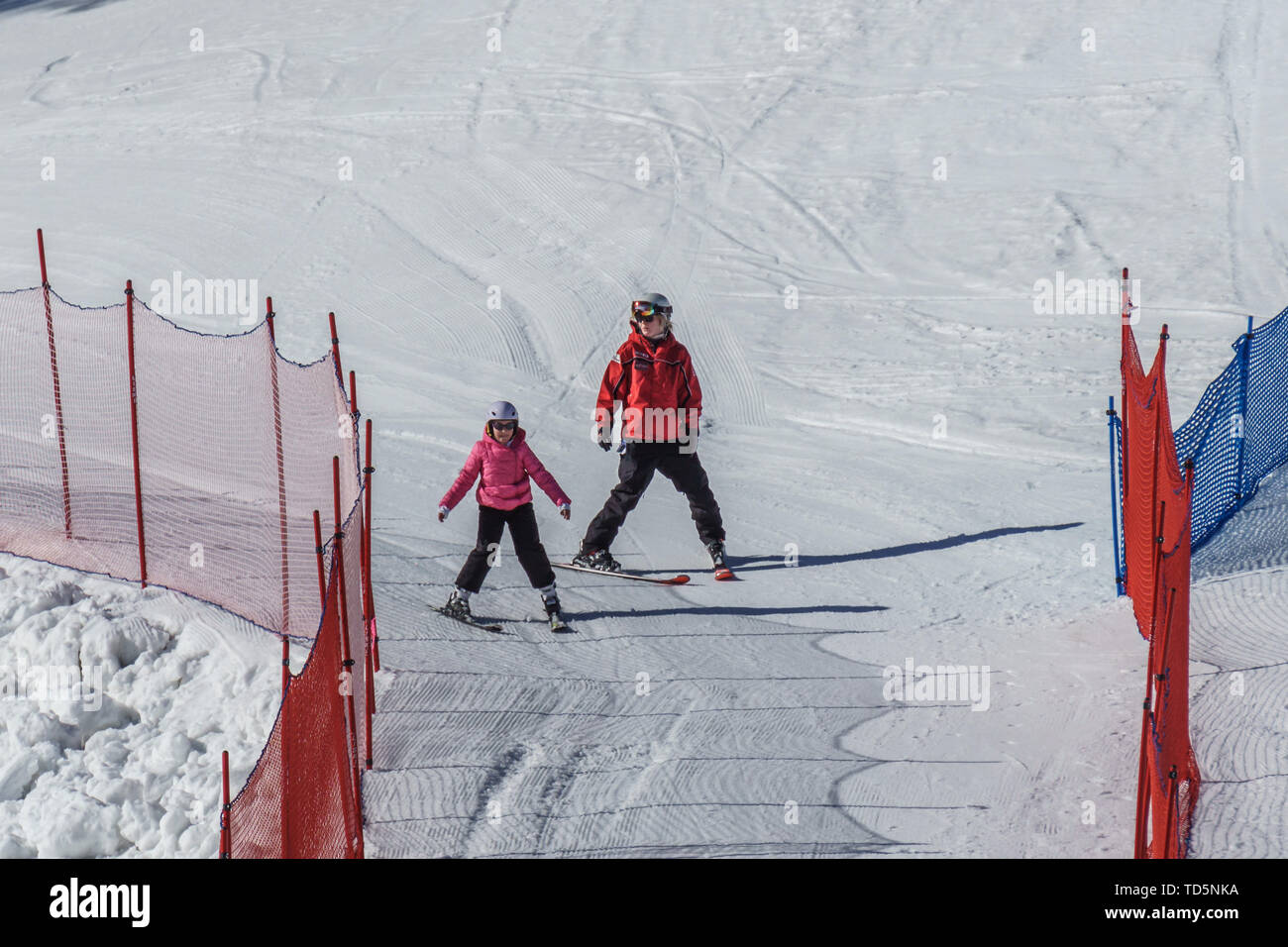 KIMBERLEY, CANADA - MARCH 22, 2019: Mountain Resort view early spring child and ski trainer skiing. Stock Photo