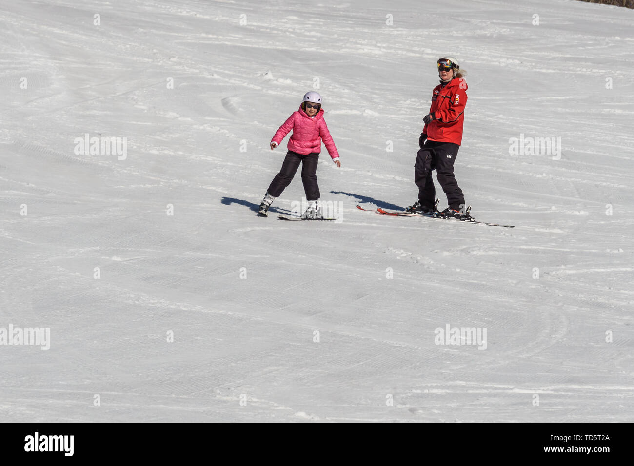 KIMBERLEY, CANADA - MARCH 22, 2019: Mountain Resort view early spring child and ski trainer skiing. Stock Photo