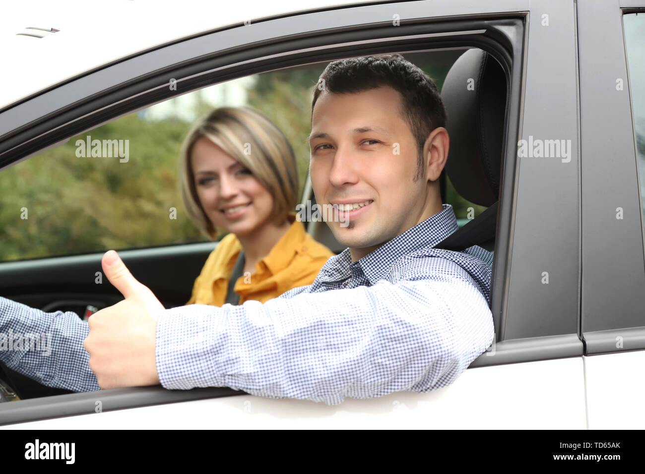 Portrait of young beautiful couple sitting in the car Stock Photo - Alamy
