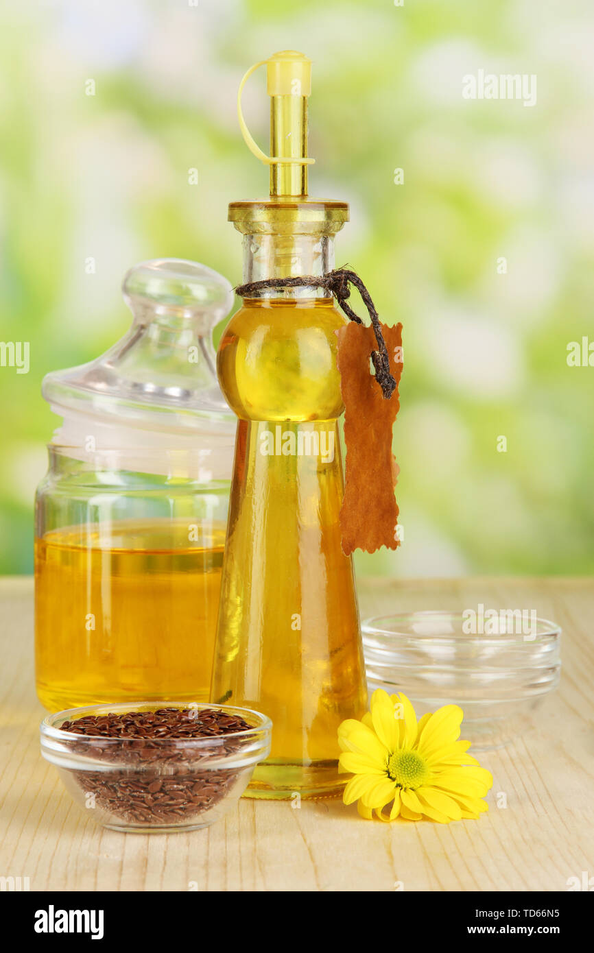 Useful linseed oil on wooden table on natural background Stock Photo