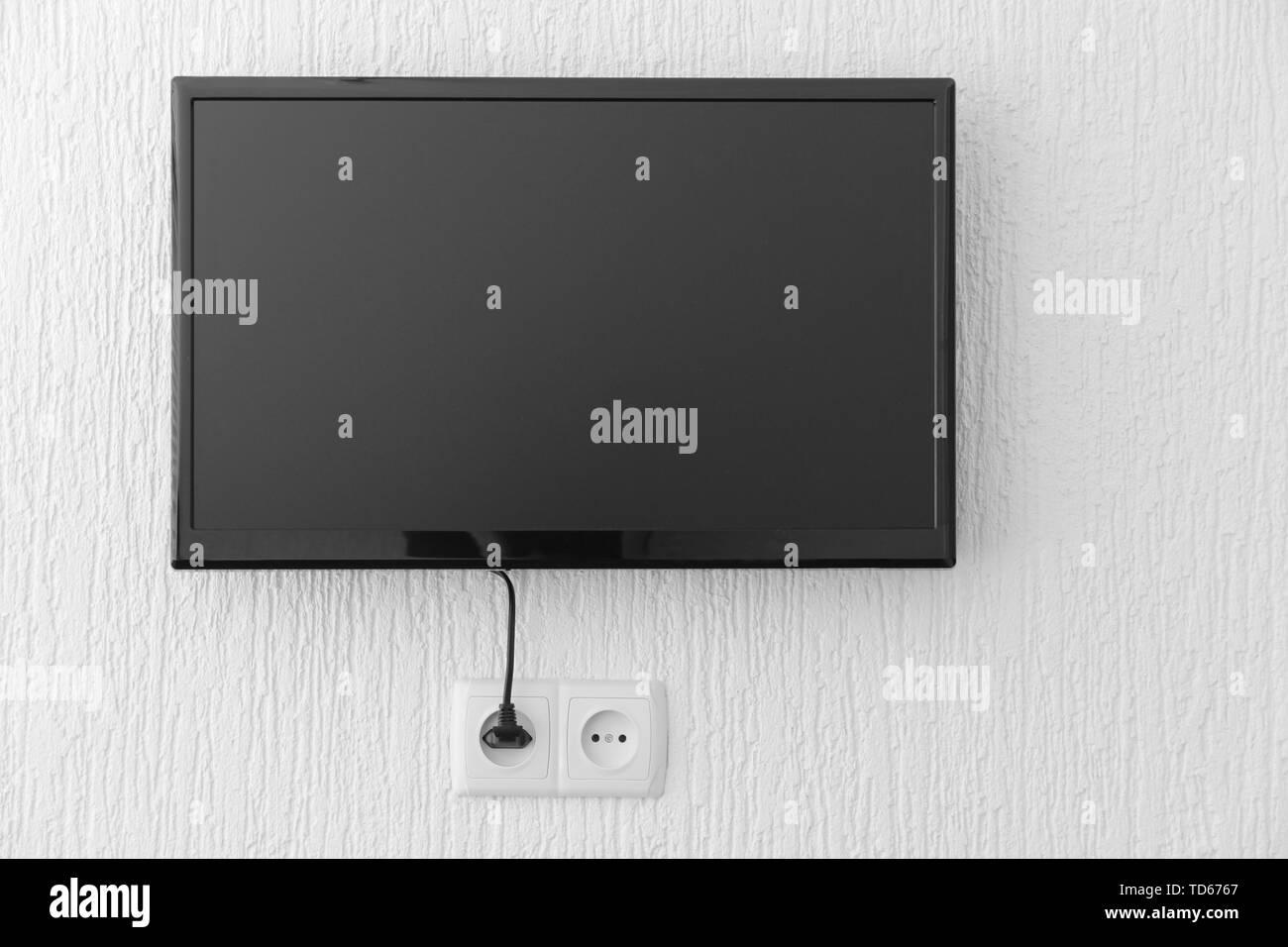 Plasma TV hanging on wall Stock Photo