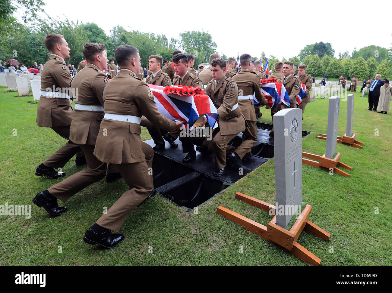 Soldiers of the Princess of Wales Royal Regiment carry the coffins of two young privates and an unknown soldier, who fought during World War One, during a burial service at Hermies Hill British Cemetery near Albert, France. Stock Photo