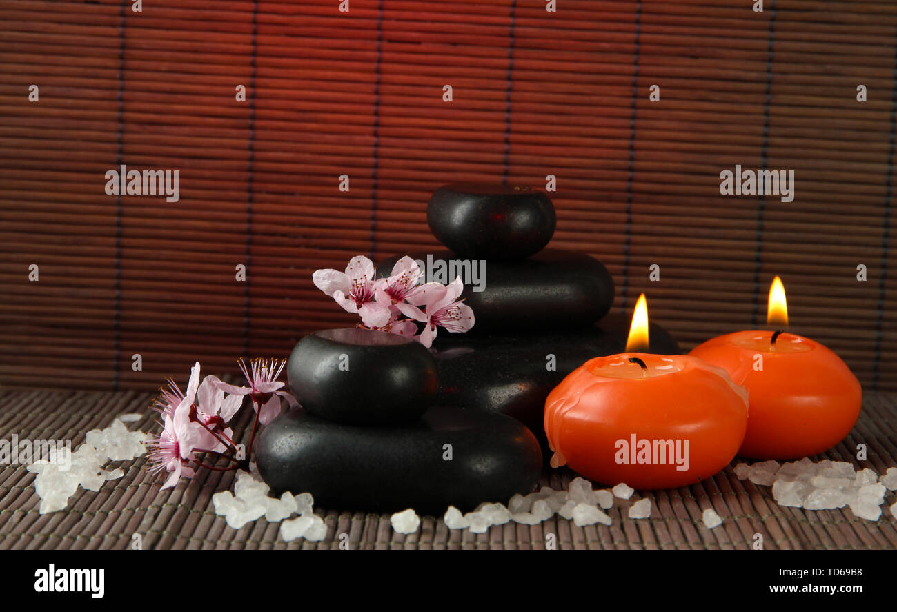 Spa stones with flowers and candles on bamboo background Stock Photo ...