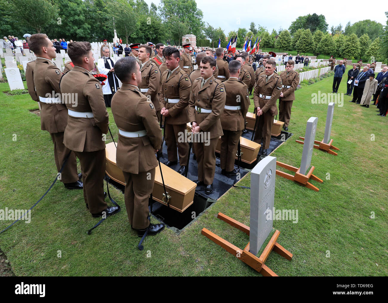 Soldiers of the Princess of Wales Royal Regiment lower the coffins of two young privates and an unknown soldier, who fought during World War One, during a burial service at Hermies Hill British Cemetery near Albert, France. Stock Photo