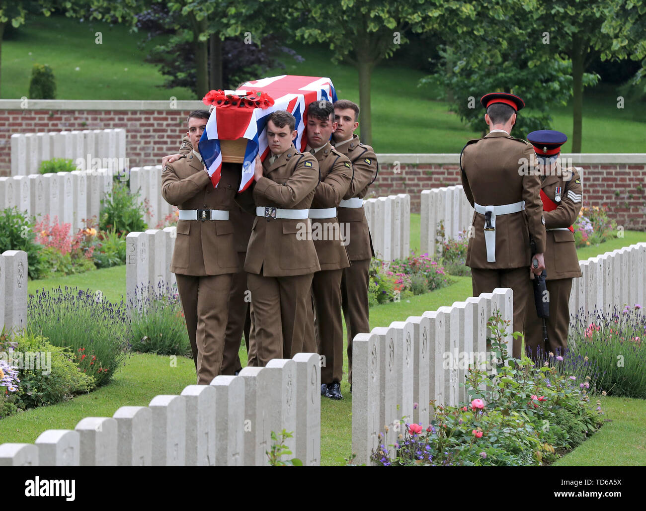 Soldiers of the Princess of Wales Royal Regiment carry one of the coffins of two young privates and an unknown soldier, who fought during World War One, during a burial service at Hermies Hill British Cemetery near Albert, France. Stock Photo