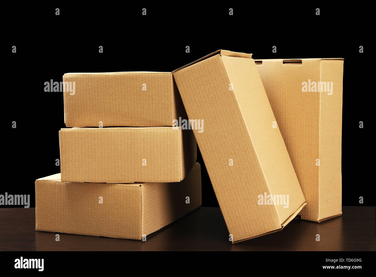 https://c8.alamy.com/comp/TD6G9G/parcels-boxes-on-wooden-table-on-black-background-TD6G9G.jpg