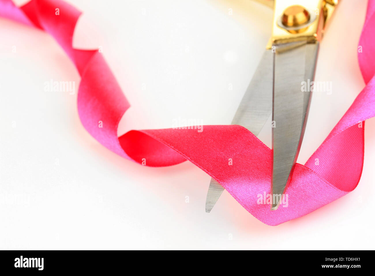 Satin ribbon curled around scissors isolated on white Stock Photo - Alamy