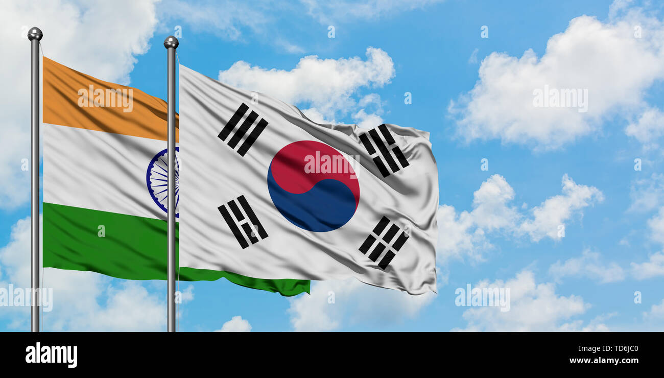 India and South Korea flag waving in the wind against white cloudy blue ...