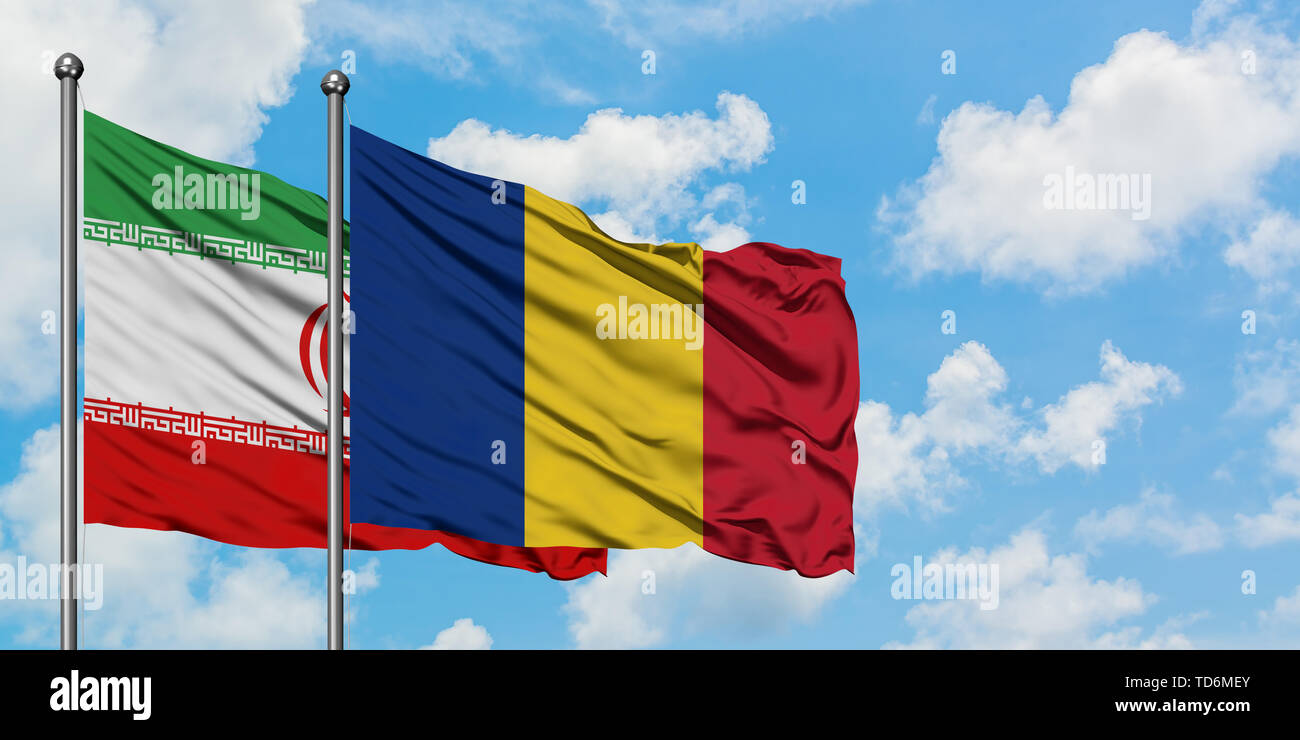 Iran and Romania flag waving in the wind against white cloudy blue sky together. Diplomacy concept, international relations. Stock Photo