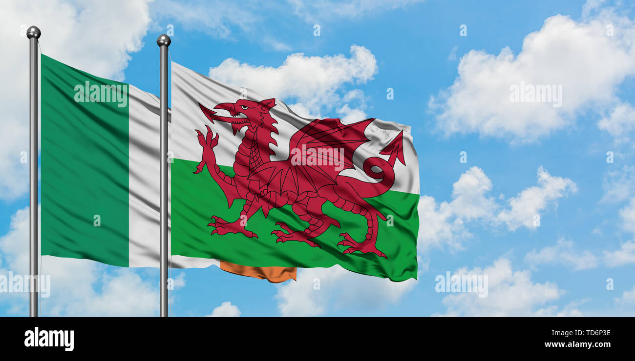 Ireland and Wales flag waving in the wind against white cloudy blue sky ...