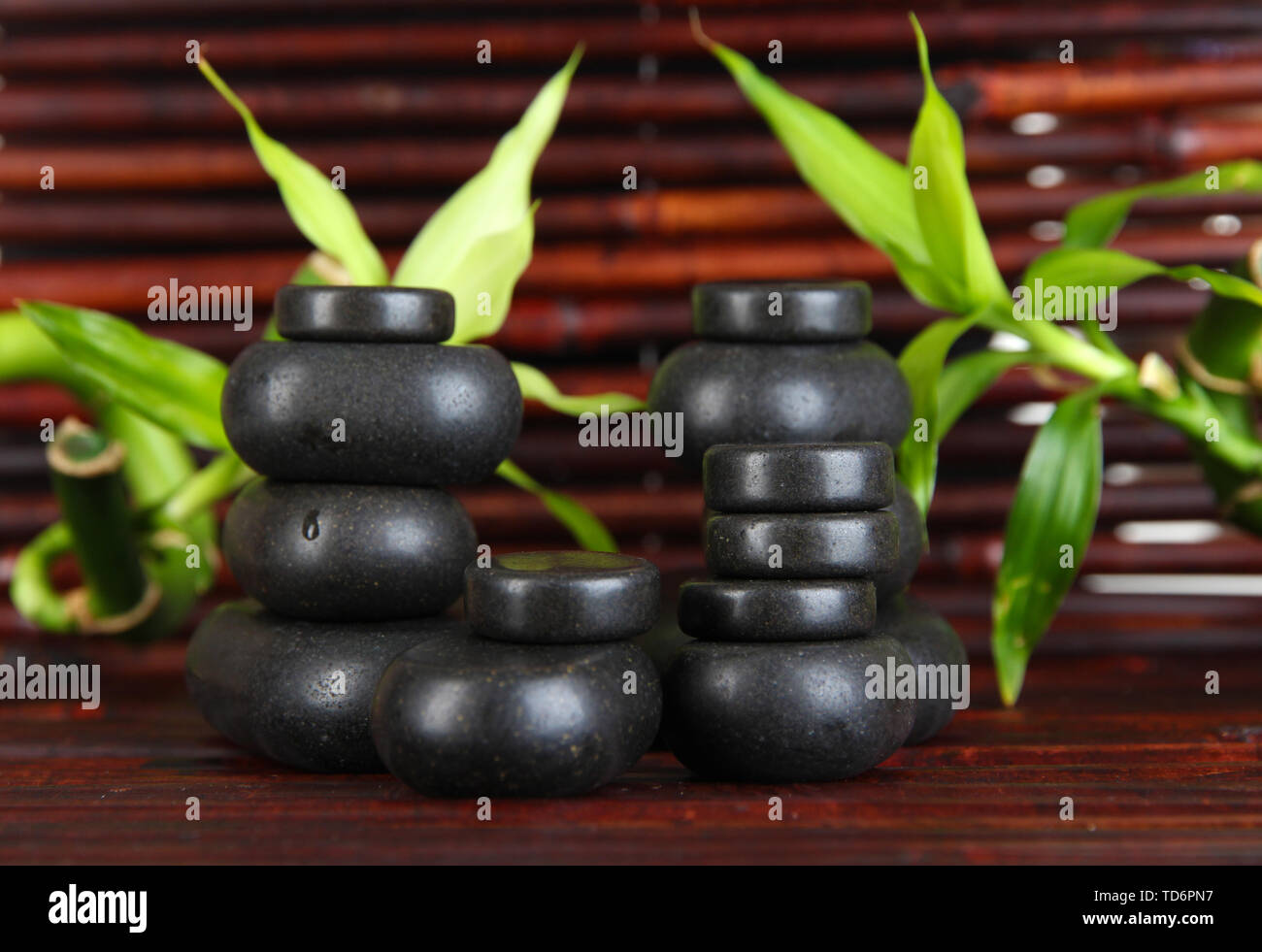 Spa stones and bamboo on bamboo mat background Stock Photo - Alamy
