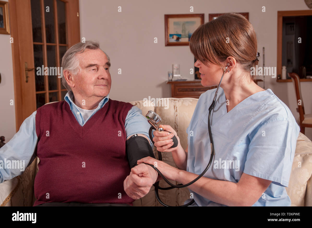Young nurse measuring seniors blood pressure Stock Photo