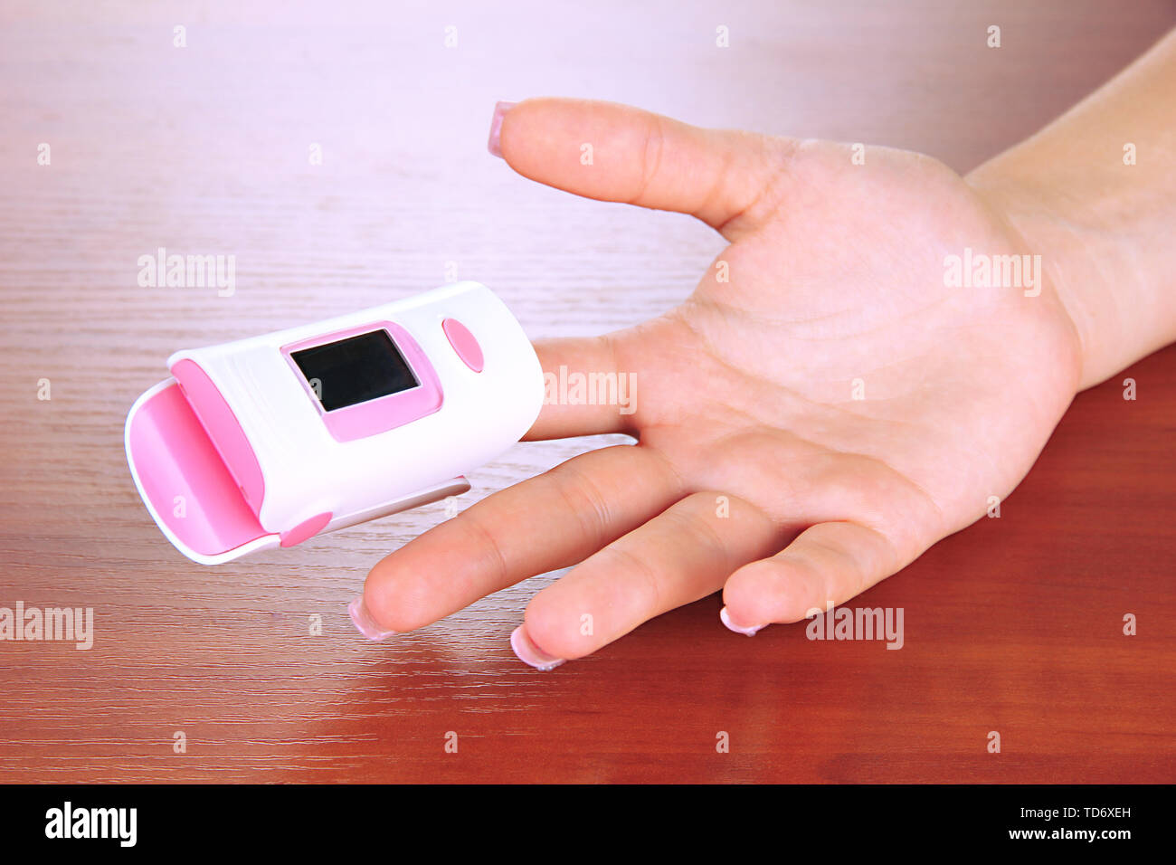 Pulse oximeter used to measure pulse rate and oxygen levels, on wooden
