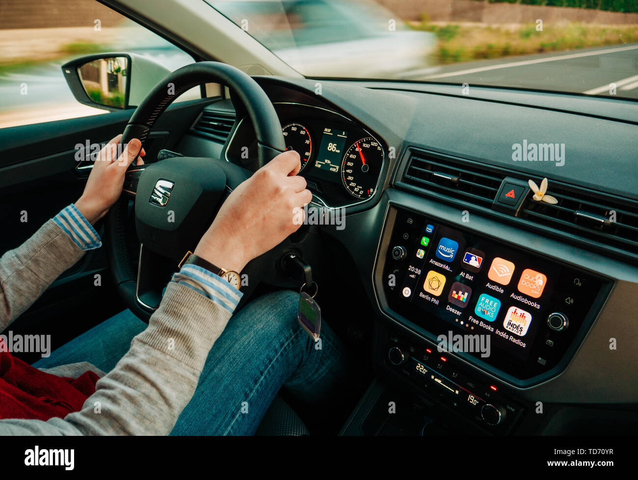 Palma de Mallorca, Spain - May 8, 2018: Young adult woman driving fast on spanish Highway at dusk a Seat car using Apple Car iOS with multiple applica Stock Photo