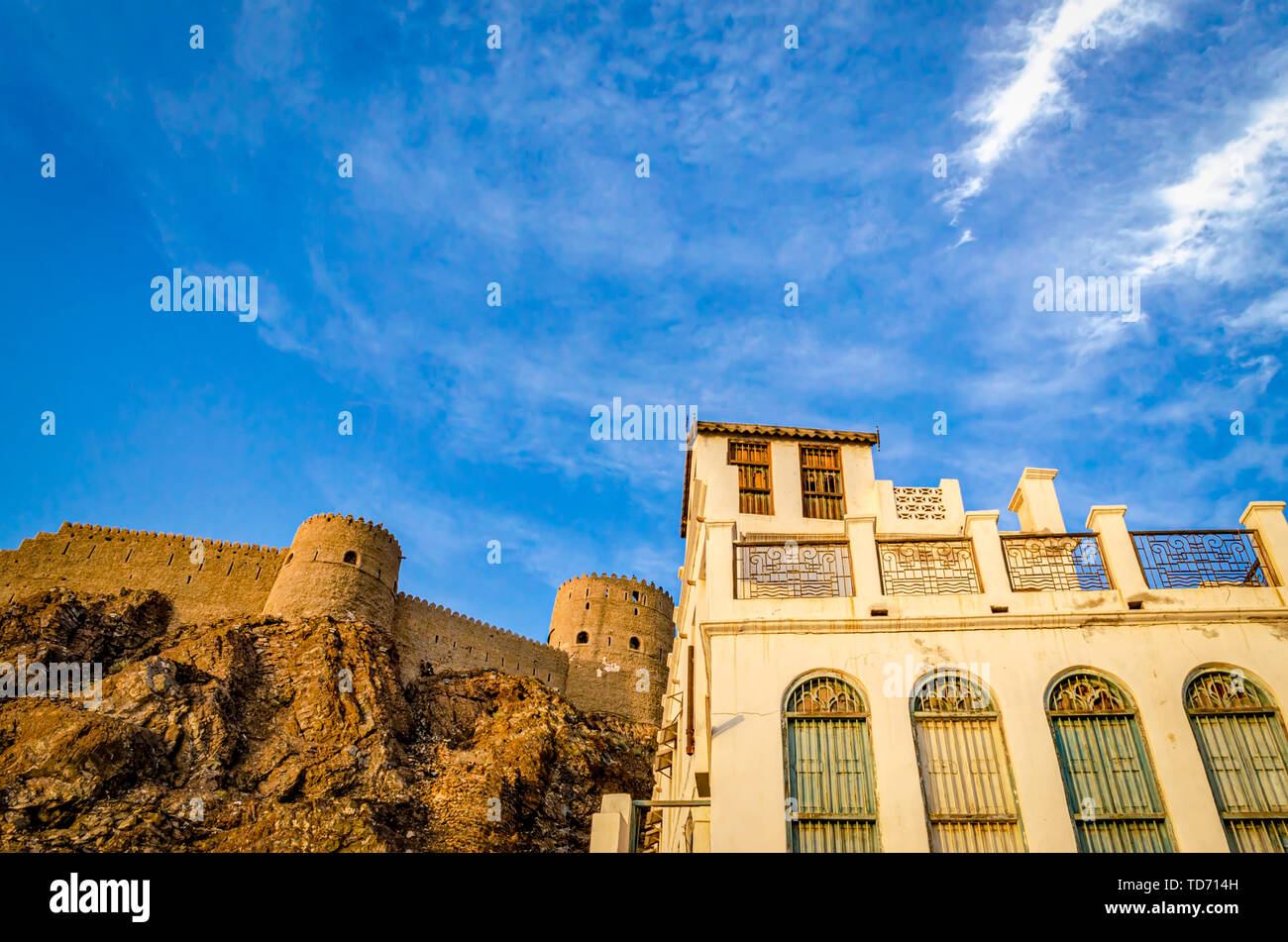 Majestic Muttrah fort adjacent to an old and abandoned house. From Muscat, Oman. Stock Photo