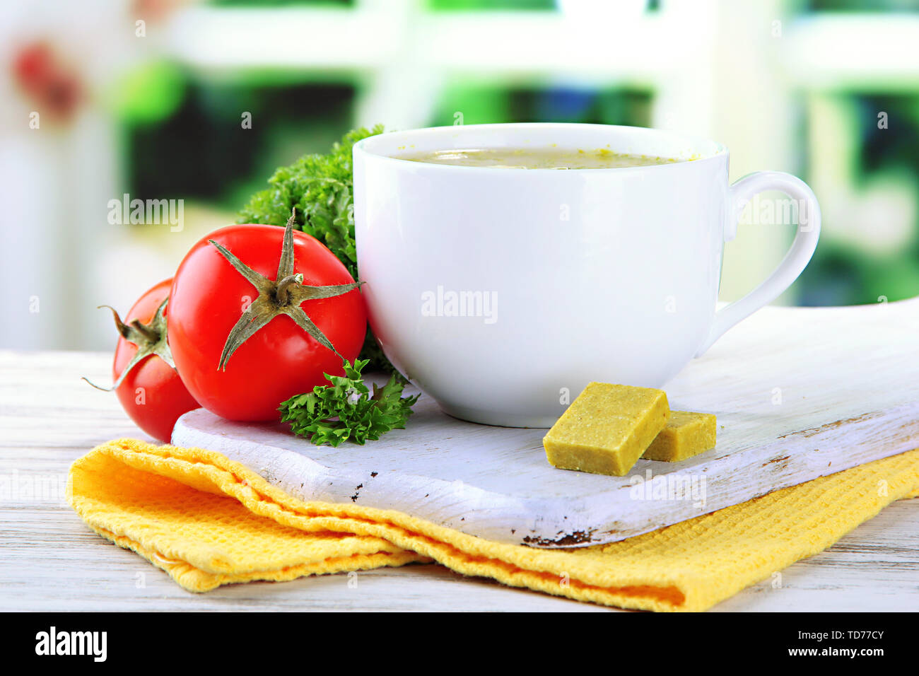 Cup of soup with bouillon cubes on wooden table Stock Photo Alamy