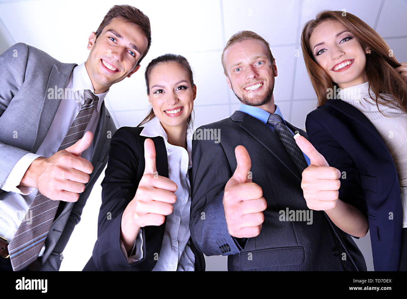 Business team showing thumbs up in office Stock Photo - Alamy