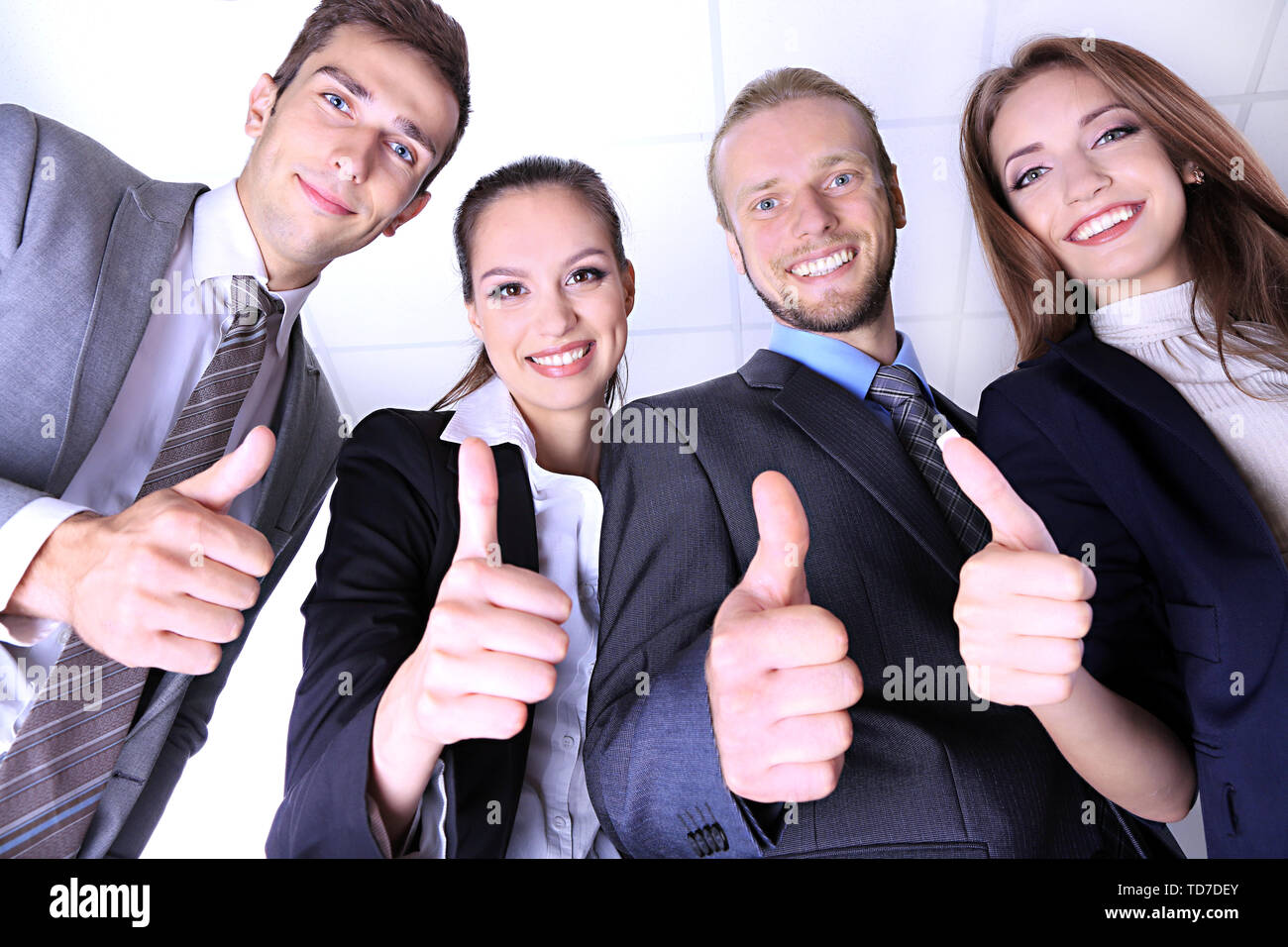 Business team showing thumbs up in office Stock Photo - Alamy