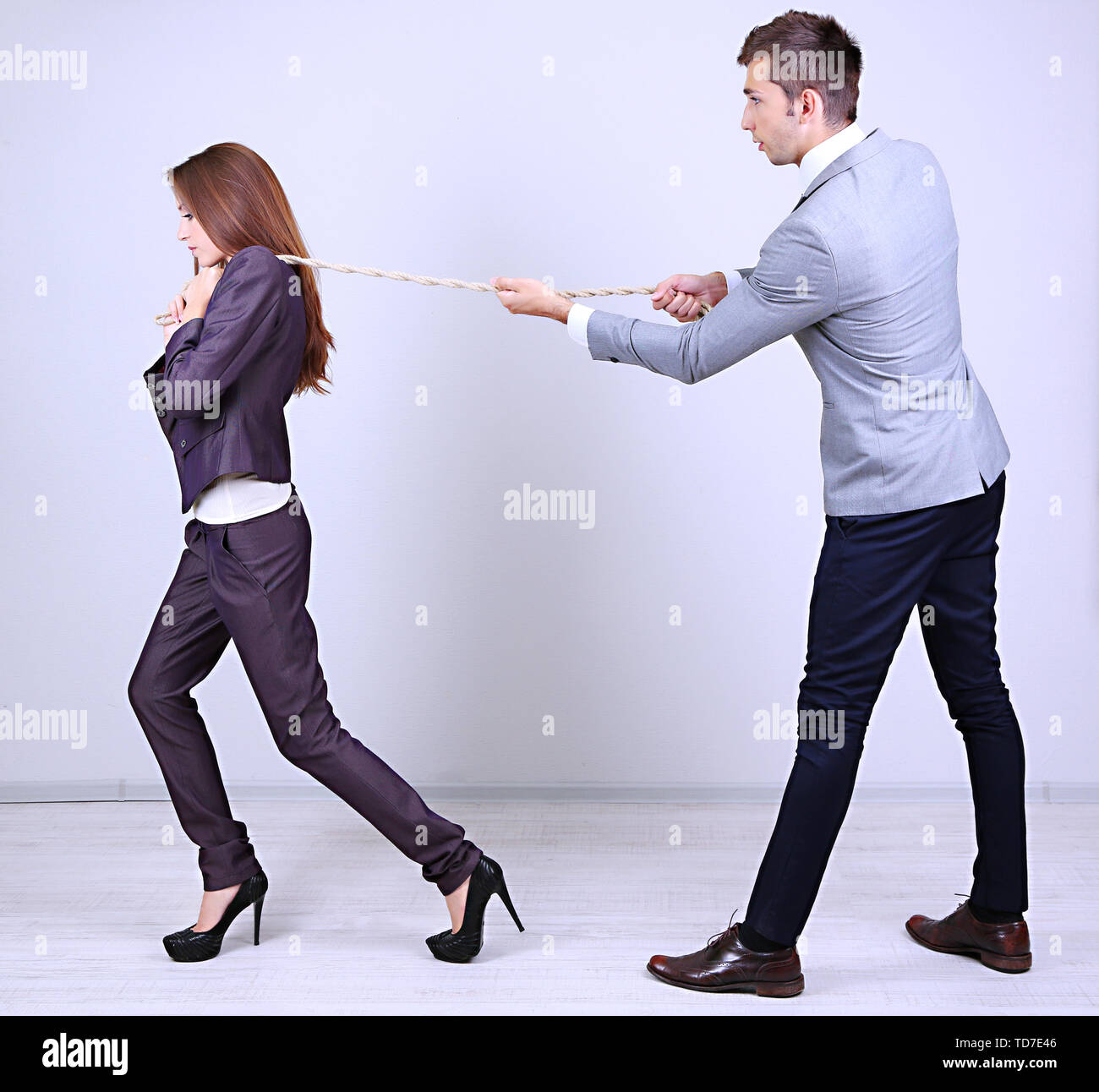 Business people stretching rope Stock Photo - Alamy