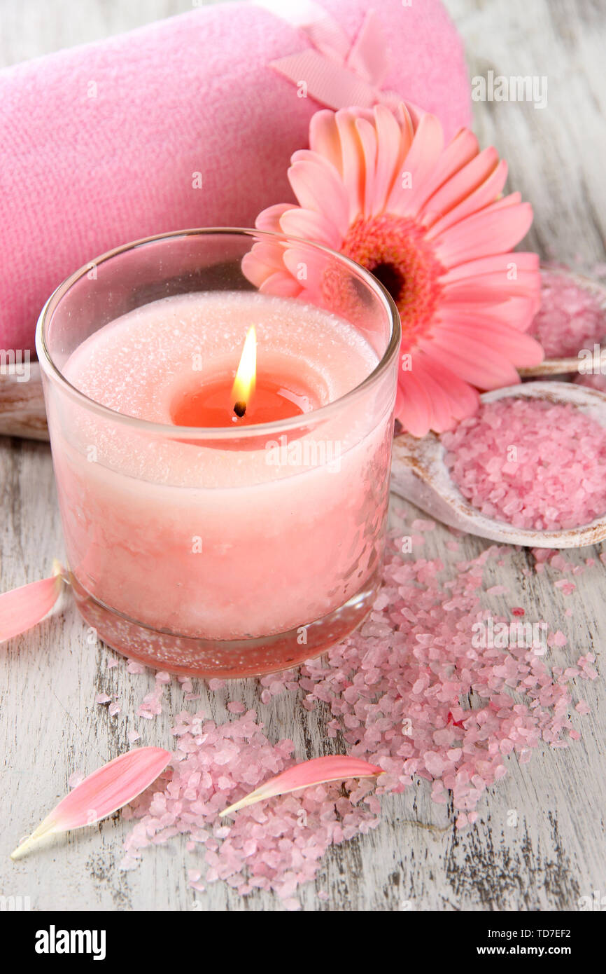 Beautiful spa setting with pink candle and flower on wooden background