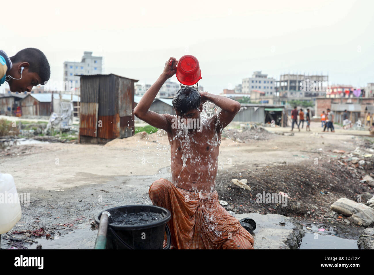 Dhaka, Bangladesh. 13th June, 2019. A worker take shower in the densely populated slum area in Dhaka Bangladesh Credit: Kazi Salahuddin/ZUMA Wire/Alamy Live News Stock Photo