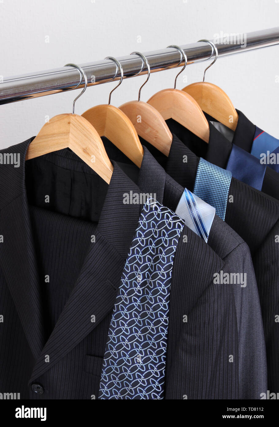Suits and ties on hangers on gray background Stock Photo Alamy