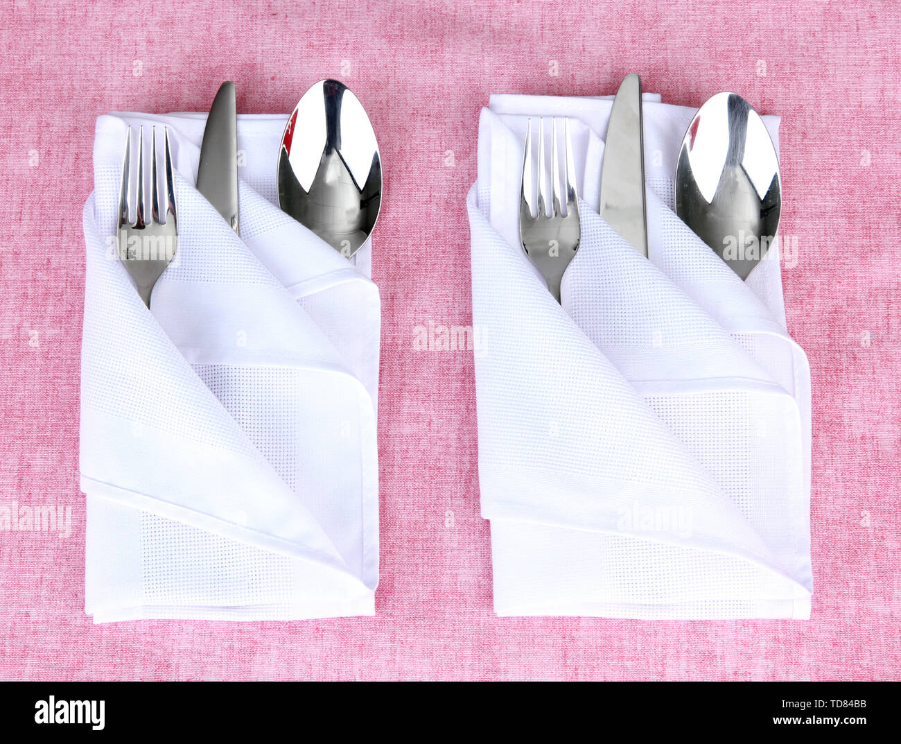 Folded napkin with fork, spoon and knife on color background Stock Photo -  Alamy