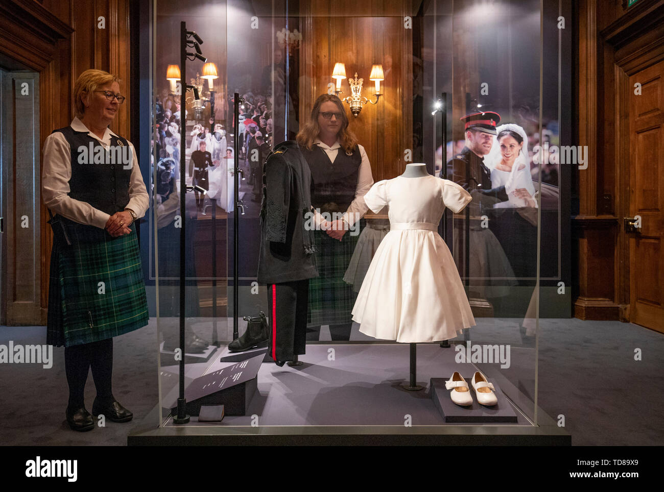 Wardens Carol Schrender (left) and Catriona Bellis take a closer look at the wedding outfits worn by Prince George and Princess Charlotte that feature in a special exhibition 'A Royal Wedding: The Duke and Duchess of Sussex' which also features a display of their Royal Highnesses' wedding outfits at the Palace of Holyroodhouse, Edinburgh. The exhibition will open to the public on Friday June 14, 2019. Stock Photo