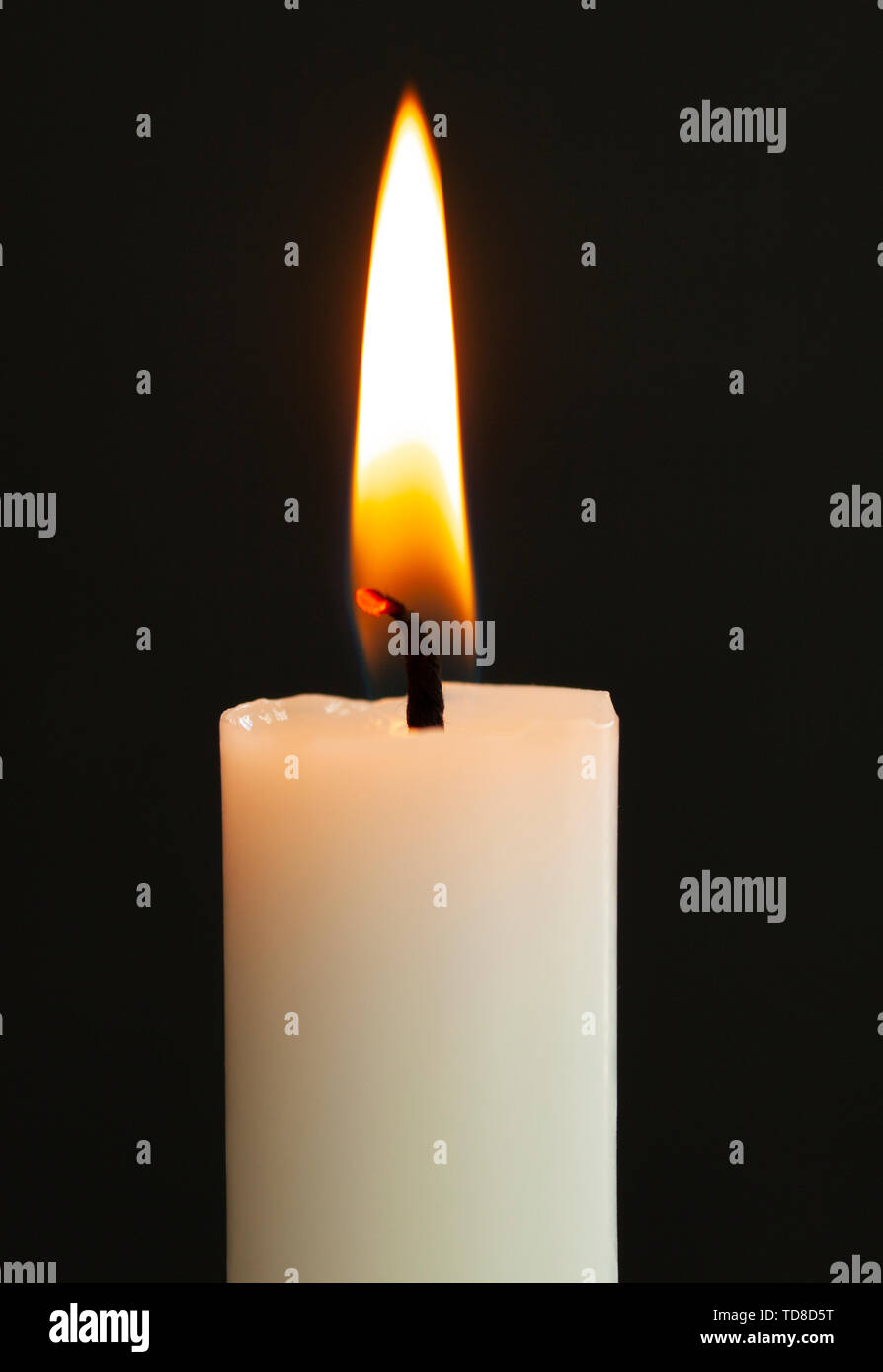 Burning candle light close up on black background Stock Photo - Alamy