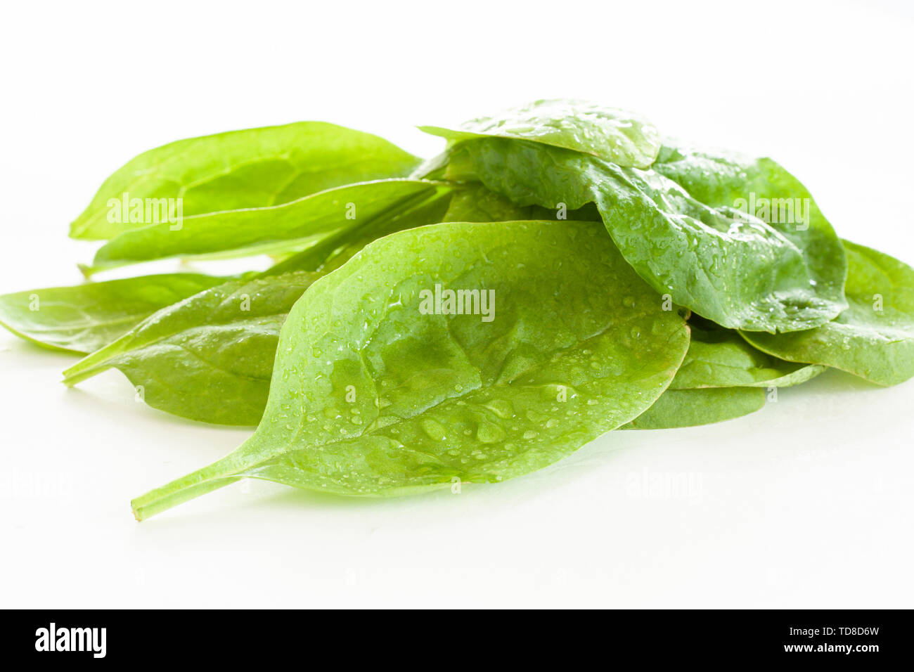 Pile of fresh green spinach leaves on white background. Close up image ...