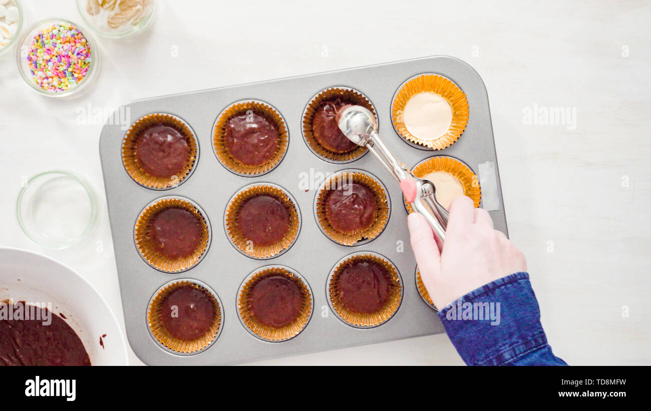 Scooping cupcake batter with a dough scoop into cupcake foil liners to bake  gingerbread cupcakes Stock Photo - Alamy